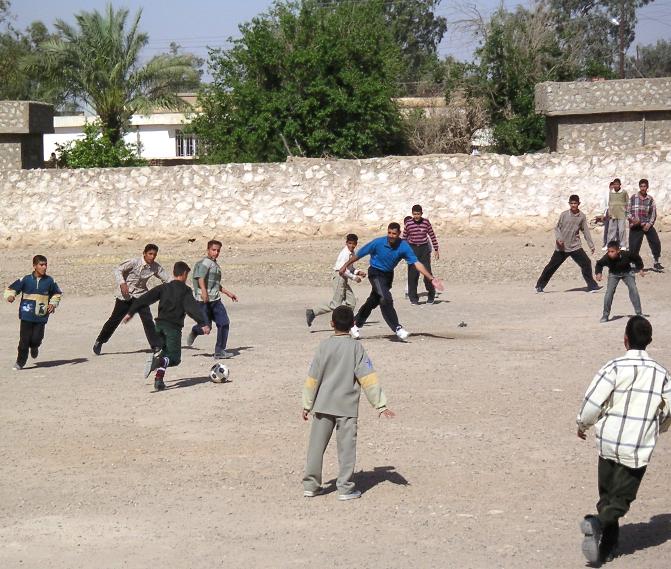Photograph of Iraqi children playing kick ball. Photograph by an American soldier of C Co, 1/252 Army Reserve Battalion. 