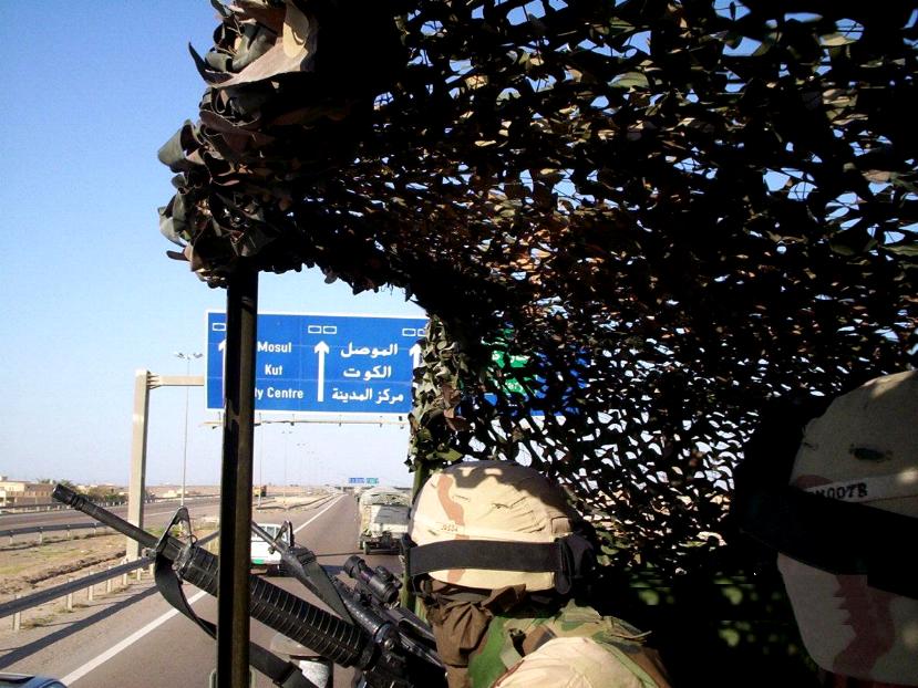 Photograph of an Iraqi highway sign from the point of view of a soldier ridding in the Humve. Photograph by an American soldier of C Co, 1/252 Army Reserve Battalion. 
