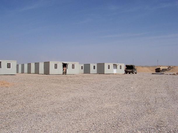 Photograph of an American soldier standing in a doorway of his hut in Iraq, taken by an American soldier of C Co, 1/252 Army Reserve Battalion. 